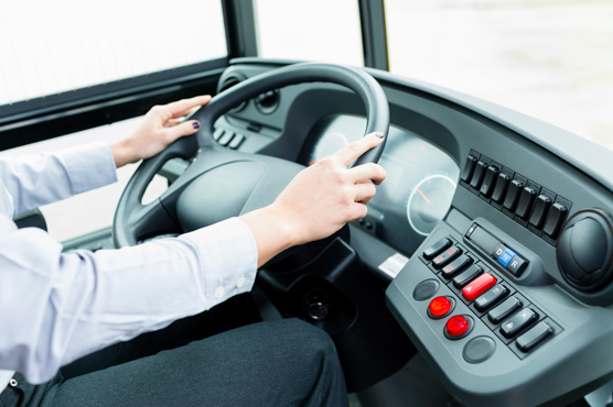 Bus driver's hands holding a steering wheel