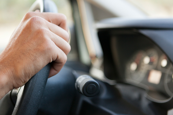 Driver's hand on steering wheel of vehicle